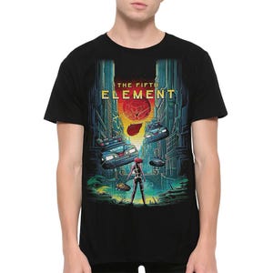 May include: Black t-shirt featuring a graphic from "The Fifth Element" movie. The design includes futuristic cityscapes, flying police cars, and the film's title in gold lettering. A female figure stands in the foreground.