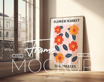 Pode incluir: Um poster emoldurado com o texto "FLOWER MARKET LOS ANGELES" apresenta um design floral com flores laranja e vermelhas e folhas azuis sobre um fundo rosa. O poster está encostado a uma parede branca perto de uma janela.