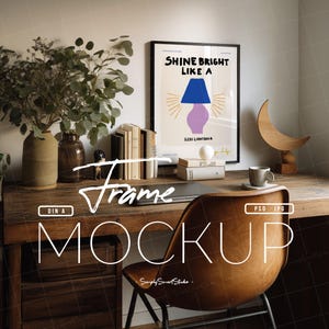 Puede incluir: Un póster enmarcado con el texto "SHINE BRIGHT LIKE A" y una ilustración de una lámpara. El póster está sobre un escritorio de madera con libros, un jarrón con vegetación y una silla de cuero marrón. La imagen es una maqueta.
