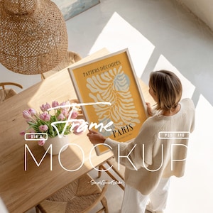 以下が含まれることがあります： 「PAPIERS DÉCOUPÉS PARIS」の文字が入った、明るい木製フレームの額装アートプリント。 黄色と青の抽象的な形が黄色の背景に描かれています。 フレームは、ピンクのチューリップの花瓶が置かれた木製のテーブルの上に置かれています。