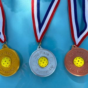 Conjunto de medalhas de pickleball - ouro, prata e bronze com fita.
