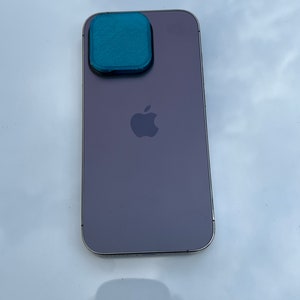 K&ouml;nnte beinhalten: Ein lila iPhone mit einer t&uuml;rkisfarbenen Kameraobjektivabdeckung.