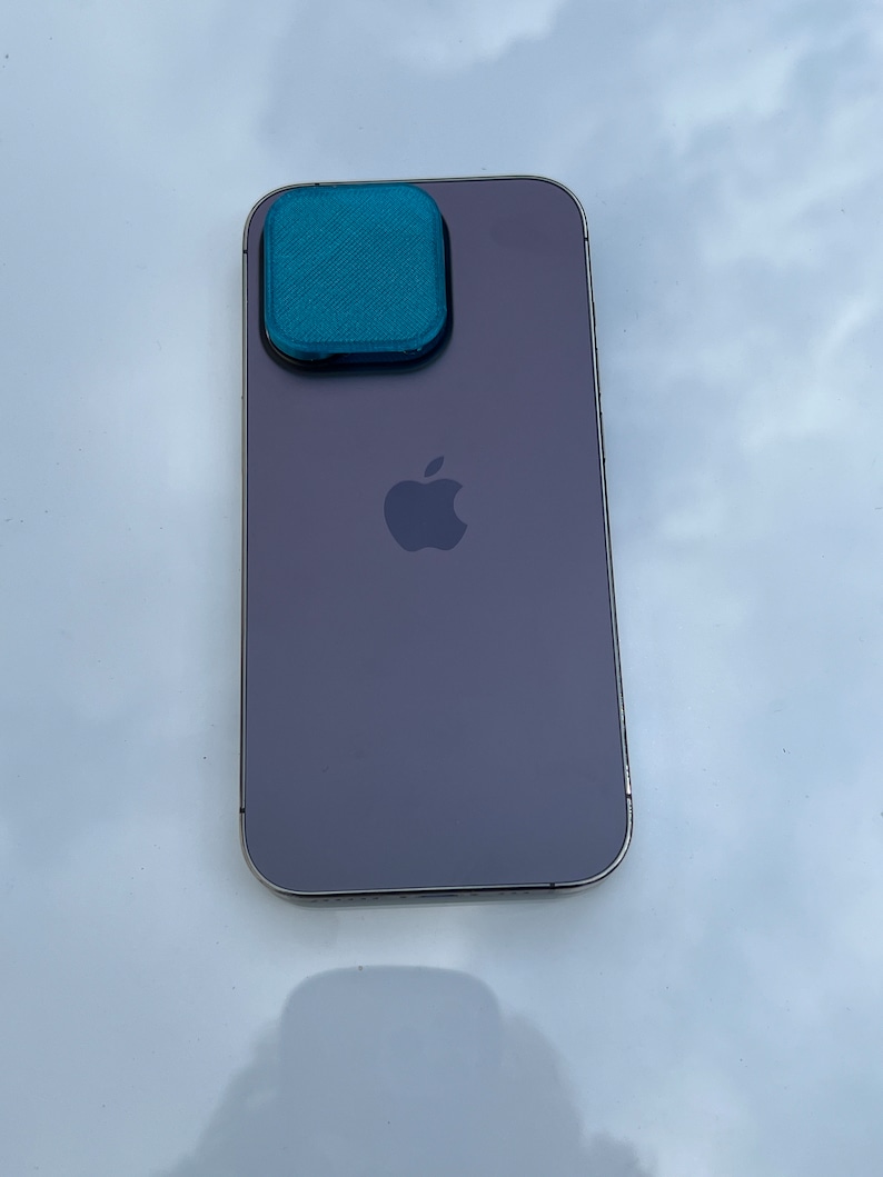 K&ouml;nnte beinhalten: Ein lila iPhone mit einer t&uuml;rkisfarbenen Kameraobjektivabdeckung.