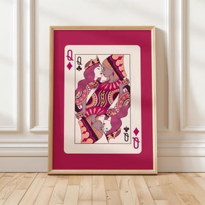 Könnte beinhalten: Gerahmter Kunstdruck einer Spielkarte, der Karo-Dame. Die Karte zeigt zwei sich küssende Frauen in Pink-, Lila- und Pfirsichtönen. Der Rahmen ist helles Holz, und das Passepartout ist ein tiefes Pink.
