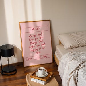 Uplifting pink wall print reminding viewers to prioritize happiness.