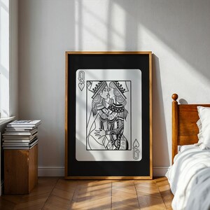 Puede incluir: Impresi&oacute;n art&iacute;stica en blanco y negro enmarcada de una carta de juego, la Reina de Corazones, que representa a dos reinas bes&aacute;ndose. La obra de arte est&aacute; en un marco de madera y se exhibe en una habitaci&oacute;n con una cama y una ventana.