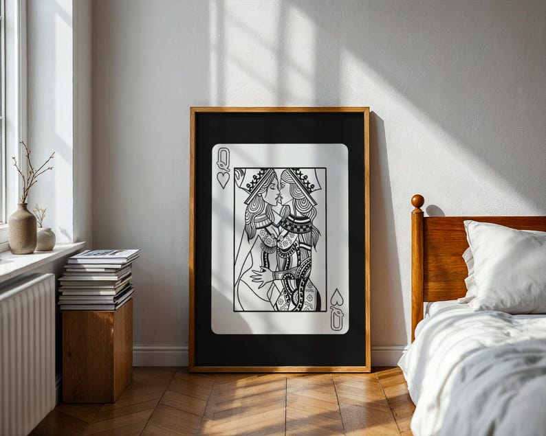 Puede incluir: Impresi&oacute;n art&iacute;stica en blanco y negro enmarcada de una carta de juego, la Reina de Corazones, que representa a dos reinas bes&aacute;ndose. La obra de arte est&aacute; en un marco de madera y se exhibe en una habitaci&oacute;n con una cama y una ventana.