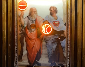 May include: A framed painting of two men in Renaissance-era clothing, with a basketball and the word "LAKERS" in neon lights. The painting is set against a wood-paneled wall.
