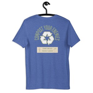 May include: A royal blue t-shirt with a green and white recycling symbol and the text "Compost Your Enemies" in a circle around the symbol. Below the symbol is a small rectangle with the text "Start an Eco Friendly Garden".