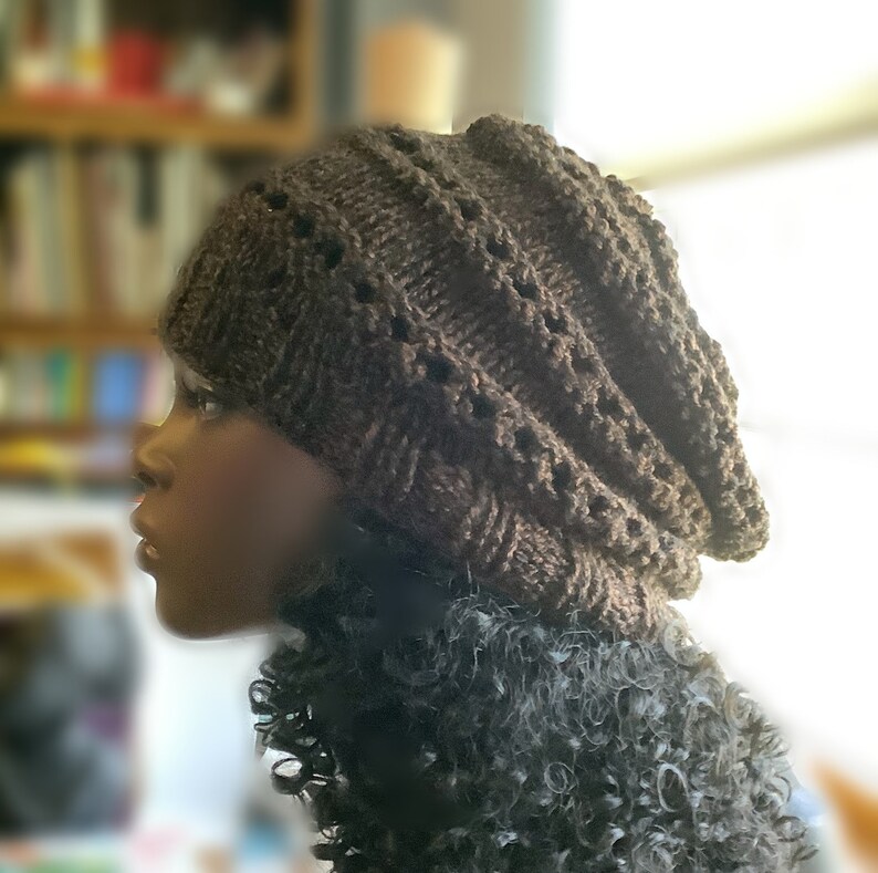 May include: A brown knitted beanie with a slouchy fit and a cable knit pattern.