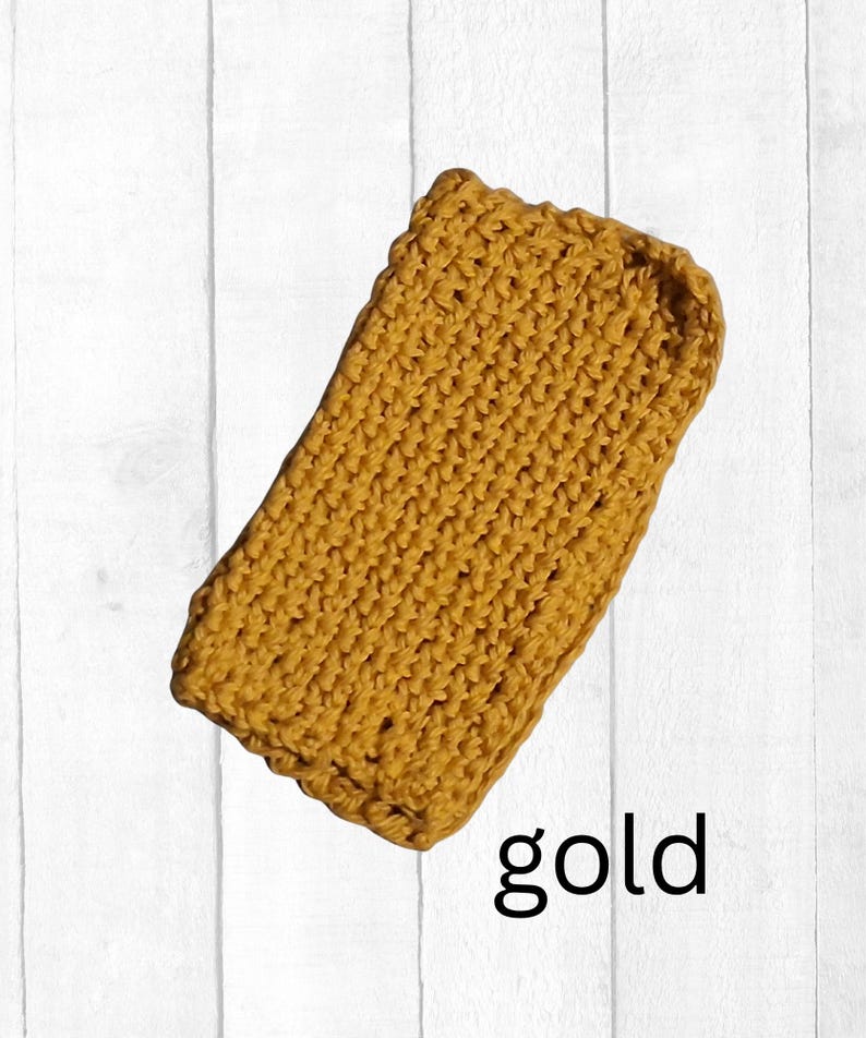 May include: A rectangular, gold-colored, crocheted item. The item is made with a thick yarn and has a textured appearance. The word "gold" is written in black script at the bottom of the image.