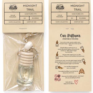 May include: A clear glass car air freshener bottle with a light wood cap and a braided rope hanger, packaged in a tan cardboard sleeve labeled Midnight Trail. The packaging includes 8ml capacity text and detailed car diffuser instructions.
