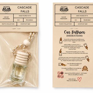 May include: A clear glass car air freshener bottle with a light wood cap and a braided cord, packaged in a clear plastic sleeve with a tan header card labeled Cascade Falls, 8ml, and Appalachian Adventure. The back card features instructions.