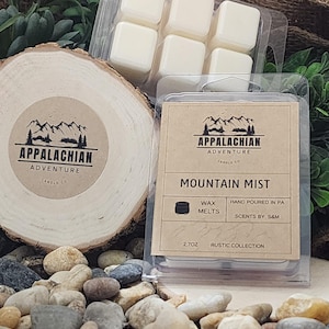 May include: A six-pack of wax melts in a clear plastic container. The wax melts are white and have a brown label that says "Appalachian Adventure Candle Co. Mountain Mist Wax Melts Hand Poured in PA Scents by S&M 2.7 oz Rustic Collection"
