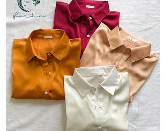May include: Four satin shirts in different colors: red, orange, beige, and white. Each shirt has a button-down collar and long sleeves.
