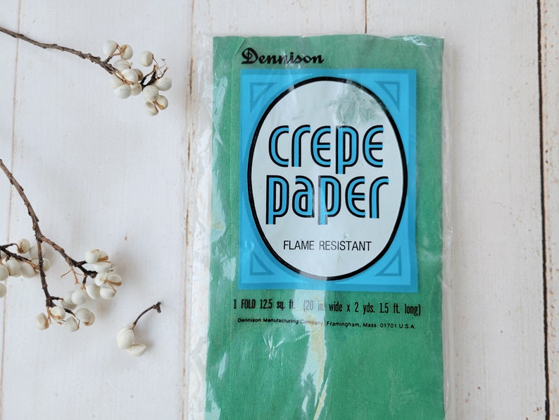 May include: A package of green crepe paper, labeled "Dennison crepe paper" and "Flame Resistant". The package states that it contains 125 square feet of paper, which is 20 inches wide by 2 yards long.