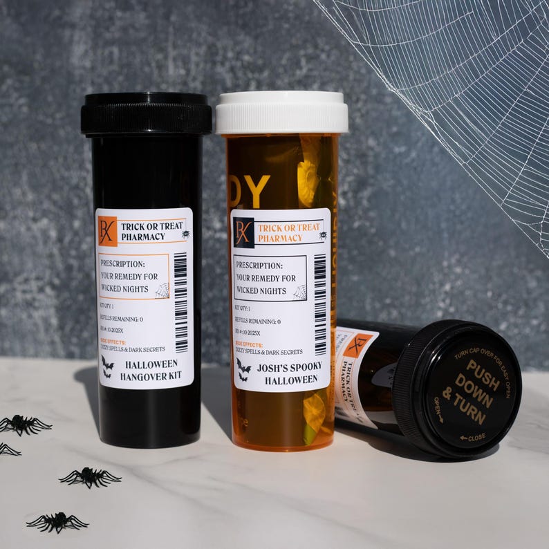 Op de afbeelding: Drie apotheekflessen met Halloween-thema. E&eacute;n zwarte fles en &eacute;&eacute;n amberkleurige fles staan rechtop, met een derde fles die op zijn kant ligt. Elke fles heeft een label met de tekst "Trick or Treat Pharmacy" en "Halloween Hangover Kit."