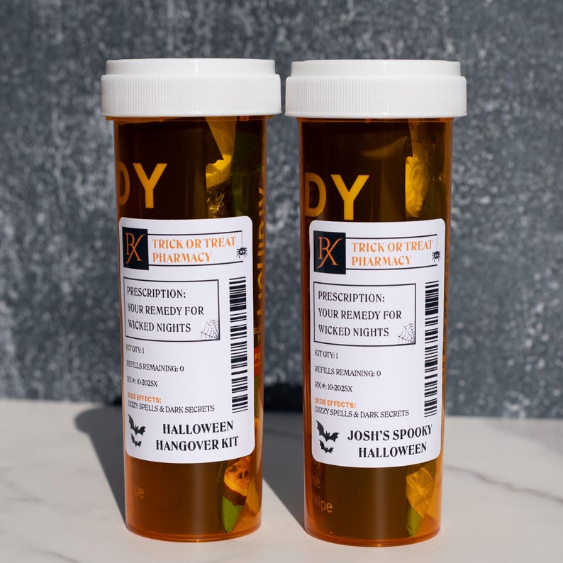 Op de afbeelding: Twee oranje medicijnflesjes met witte deksels. Elk flesje heeft een etiket met de tekst "Trick or Treat Pharmacy" en "Halloween Hangover Kit". De etiketten bevatten ook de tekst "Your Remedy for Wicked Nights."