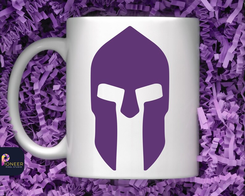 May include: White ceramic mug with a purple Spartan helmet graphic. The helmet is a silhouette with a white face mask.