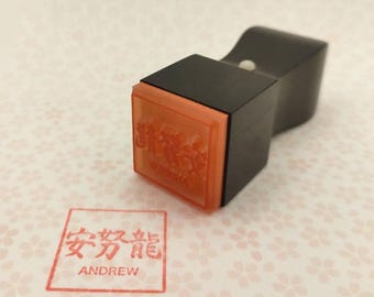 May include: A black wooden stamp with a red ink pad. The ink pad has Chinese characters and the word "Andrew" in English.