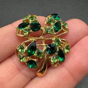 May include: A white ceramic mug with a black handle and the text "But First, Coffee" in a bold, black font. The mug is set against a neutral background, highlighting its simple design.