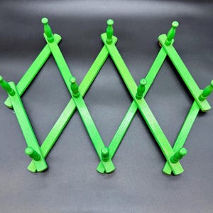 Green Peg Rack Expandable Wooden Accordion Rack 10 Pegs for Mugs Hats Coats Jewelry Made in Hong Kong 22” x 11” pegs 2.25” L Metal Hanger