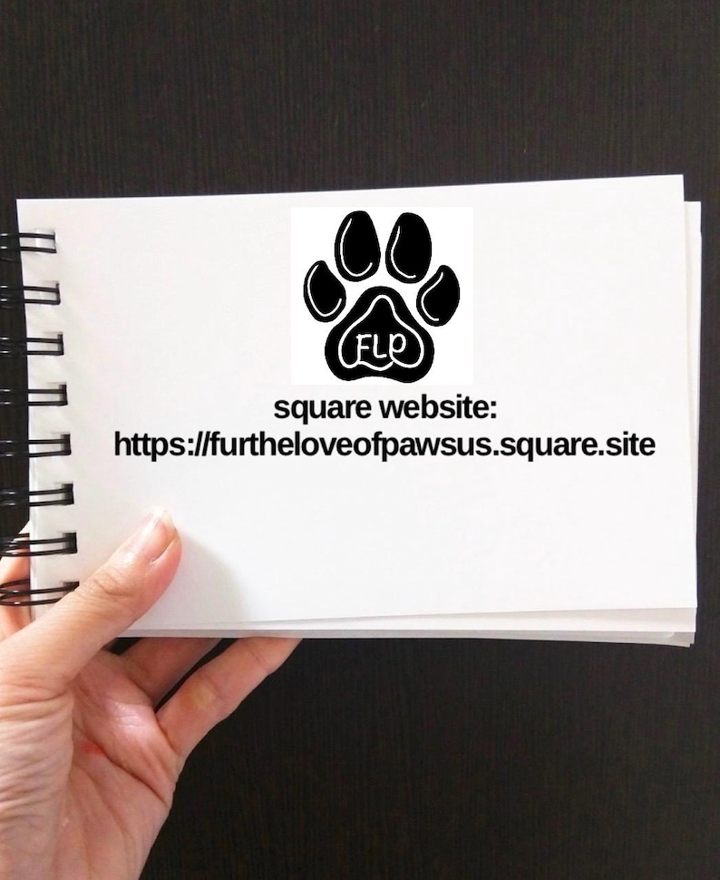 Puede incluir: Una libreta blanca con un logotipo de huella de pata negra y el texto "square website: https://furtheloveofpawsus.square.site" en la portada.