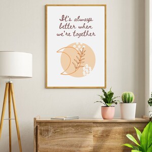 Puede incluir: Una impresión enmarcada con una luna creciente de color melocotón y un diseño floral blanco. El texto en la impresión dice "It's always better when we're together."