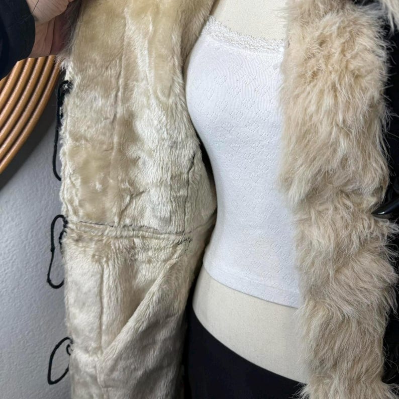 Step into timeless vintage fashion with this Handmade Black Suede Penny Lane Coat. Featuring plush cream trim along the collar, cuffs, and edges, it channels true 70s Afghan energy. The soft suede leather, flattering long cut, and warm interior make it perfect for winter layering, holiday looks, retro outfits, and everyday boho chic styling.