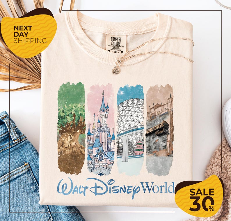 a white t-shirt with a graphic design depicting various Disney landmarks, including the Walt Disney World resort, the Eiffel Tower, and the Hollywood sign. The t-shirt is displayed on a white background, and there are two yellow sale signs indicating a 30% discount on the item.