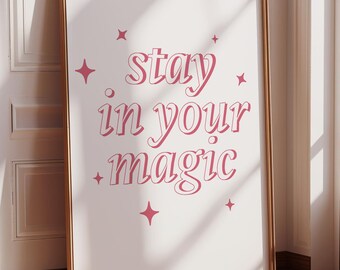 May include: A white framed poster with pink text that reads "stay in your magic" with pink stars around the text.