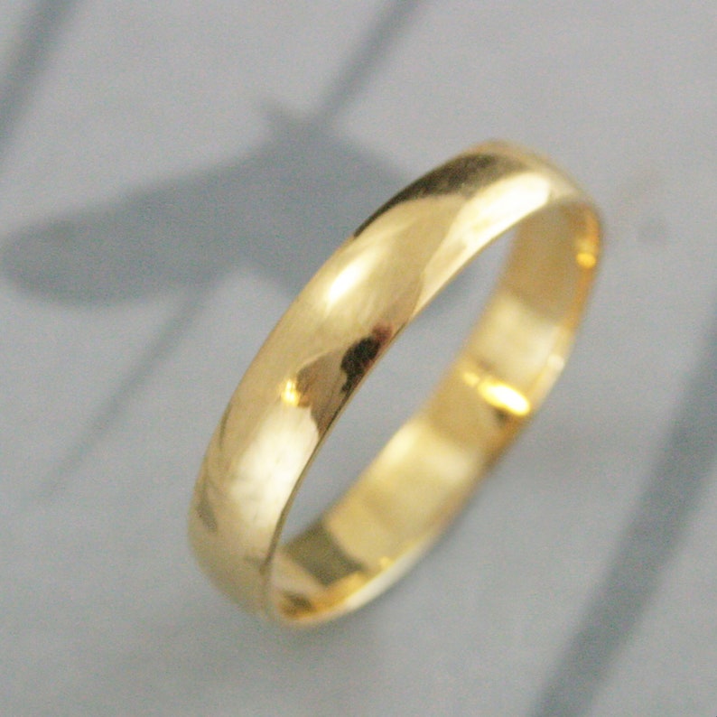 May include: A simple gold wedding band with a smooth, polished finish.