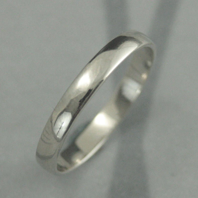 May include: A simple, polished silver wedding band.