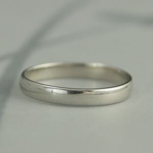 May include: A simple, polished silver wedding band.
