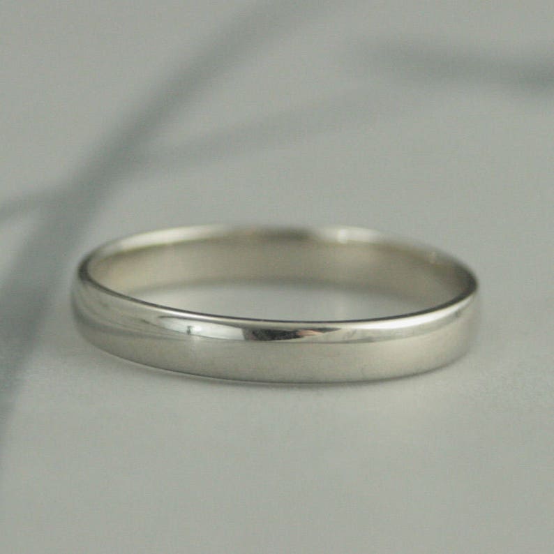 May include: A simple, polished silver wedding band.