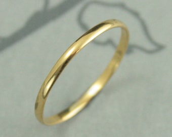 May include: A simple, thin gold band ring. The ring is smooth and polished.