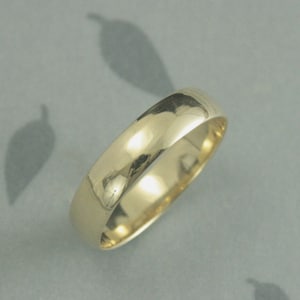 May include: A simple gold wedding band with a smooth, polished finish.
