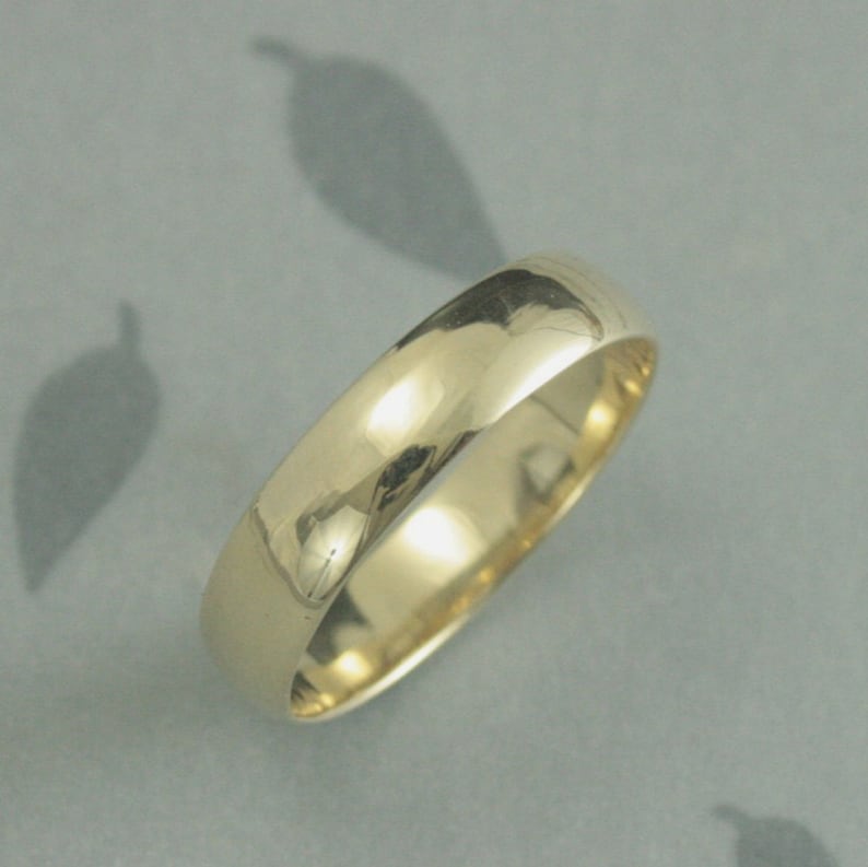 May include: A simple gold wedding band with a smooth, polished finish.