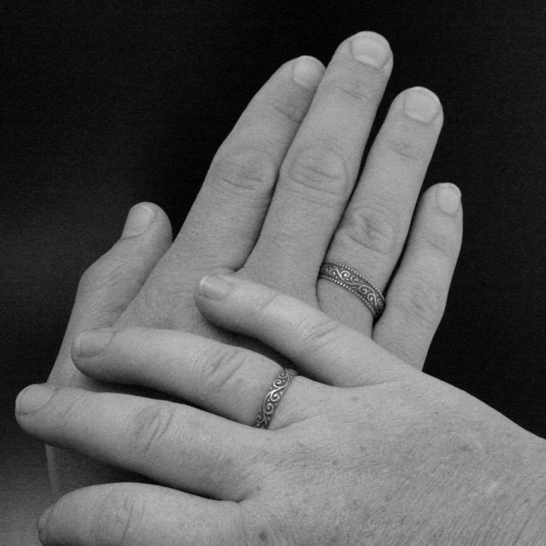 Puede incluir: Dos manos con anillos de boda en sus dedos anulares, entrelazadas entre s&iacute;.