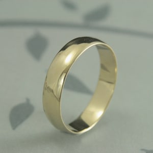 May include: A simple gold wedding band with a polished finish.