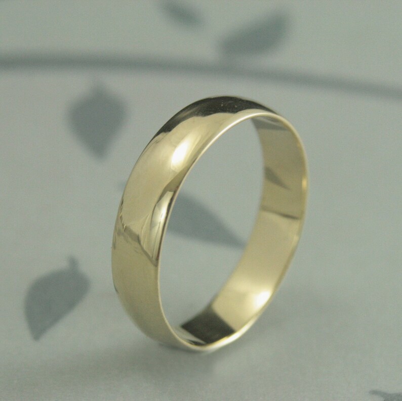 May include: A simple gold wedding band with a polished finish.