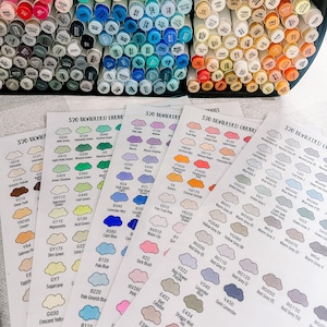 Puede incluir: Un conjunto de 320 marcadores a base de alcohol con tablas de colores que muestran los nombres y los números de los colores. Los marcadores están dispuestos en un patrón de arcoíris y están organizados por familia de colores.