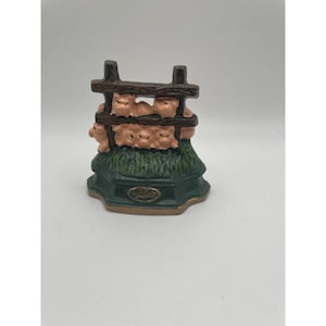 Cerdos de hierro fundido antiguos en el tope de la puerta de la cerca