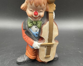 Figura de porcelana antigua de payaso y su violonchelo de Alemania
