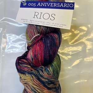 Puede incluir: Ovillo de lana Rios de grosor worsted en una vibrante mezcla de colores, incluyendo rosa, azul, verde y amarillo. La etiqueta dice "005 ANIVERSARIO" y "RIOS". La lana es 100% lana merino superwash. Aproximadamente 192 metros.