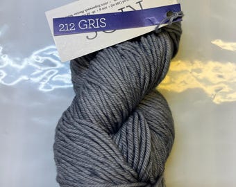 May include: A skein of gray worsted weight yarn labeled "212 GRIS" with the brand name "JUN" on the label. The yarn is 100% superwash merino wool and is 210 yards (192 meters) per 100 grams (3.5 ounces).