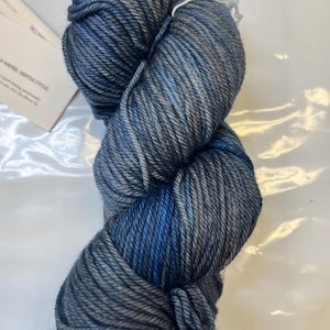 May include: A skein of blue and grey yarn with a white label that says "Cold Water, Gentle Cycle".