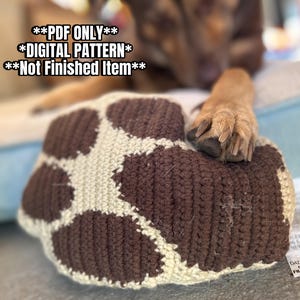 Puede incluir: Una cama para perros tejida a ganchillo con un diseño de huellas en colores marrón y crema. El texto de la imagen dice "PDF ONLY", "DIGITAL PATTERN" y "Not Finished Item".