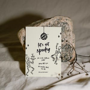May include: A cream-colored Halloween party invitation with black illustrations and text. The invitation features a disco ball, skeletons, and the phrase "let's get spooky." Additional text includes party details: Friday 31th 7 pm, 123 anywhere street, any city.