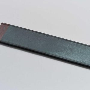 May include: A long, rectangular, gray metal bar with a pink edge.